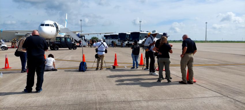 a group of people standing on a tarmac