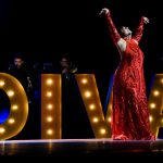 Mujer en vestido rojo con los brazos en alto