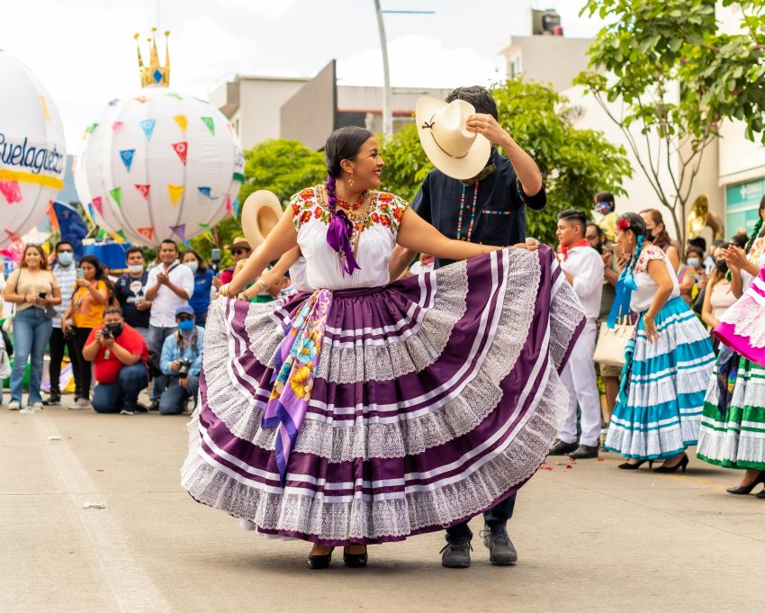 People in Costumes Dancing on a Street during the Guelaguetza Festival in Oaxaca, Mexico