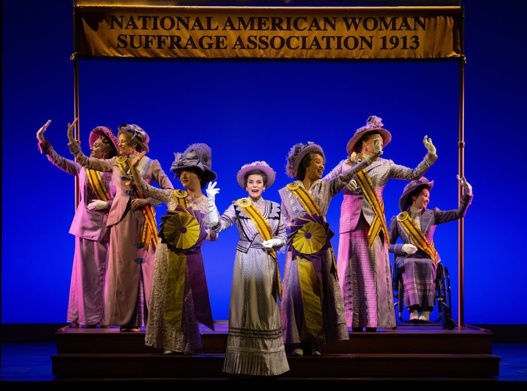 Jenn Colella as Carrie Chapman Catt and Suffs Broadway Company. Photo by Joan Marcus
