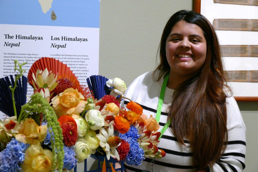 L1370914.JPG b Joven mujer sonríe junto a flores