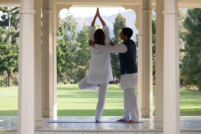 Persona hace yoga y otra le asiste